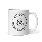 White glossy ceramic mug with black typographic design reading “Biltong & Borrelnoten,” funny South African and Dutch crossover mug.