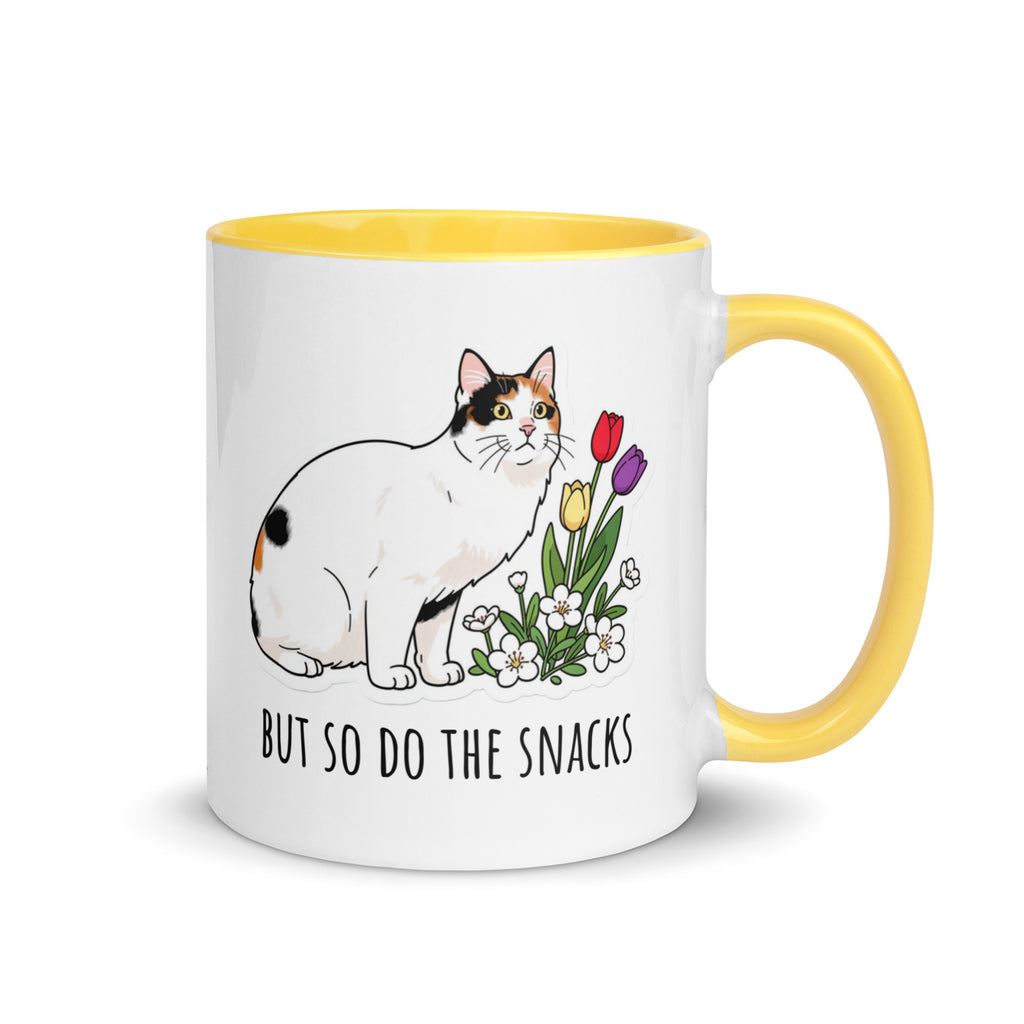 White ceramic mug with yellow rim and handle featuring calico cat Lina Love standing beside flowers and the text “The horrors persist, but so do the snacks.”