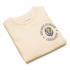 Natural kids t-shirt with small lion chest print and the phrase “Zolang je maar leeuloop,” South African Roots youth tee inspired by the Afrikaans song “Leeuloop.”