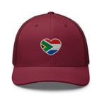 Cranberry mesh-back trucker cap with embroidered Two Homes One Heart design combining the South African and Dutch flags.