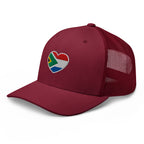 Cranberry mesh-back trucker cap with embroidered Two Homes One Heart design combining the South African and Dutch flags.